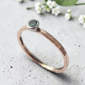 Hammered 9ct gold ring with a platinum set emerald